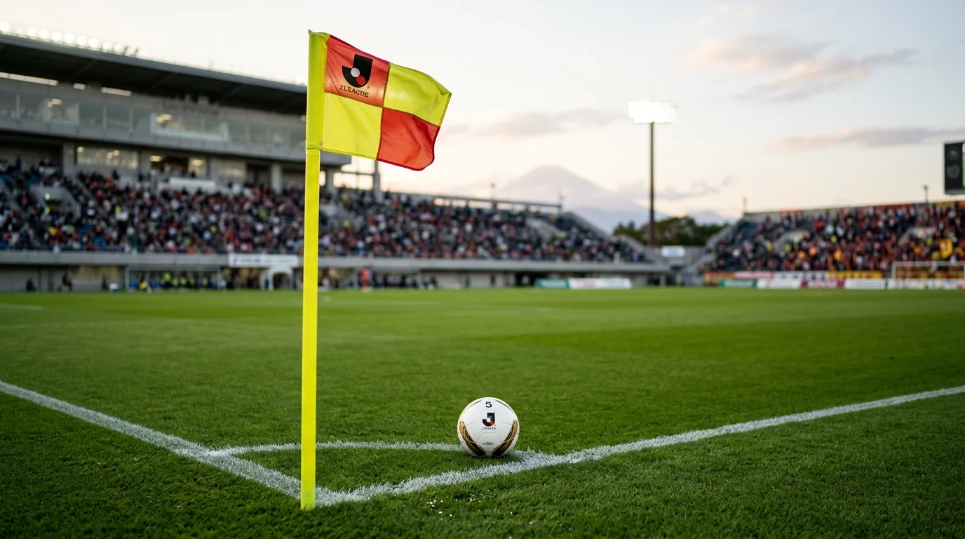 Arbitro de la J League mostrando tarjeta amarilla durante un partido con un corner al fondo